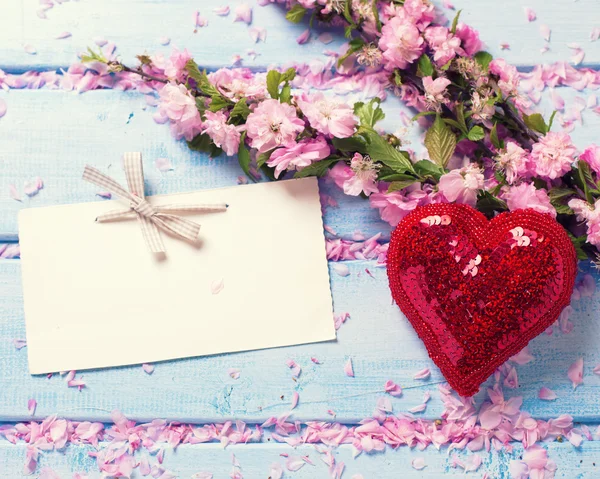 Pink sakura flowers and decorative heart — Stock Photo, Image