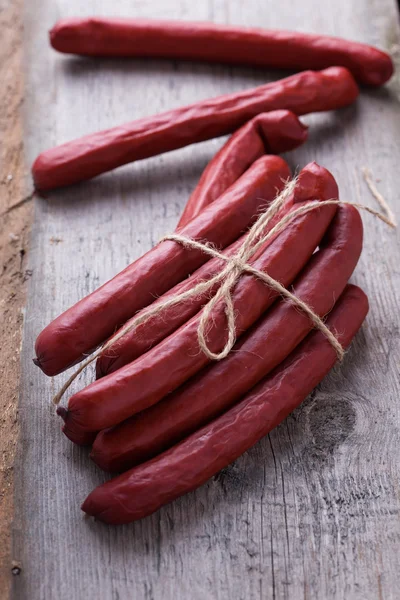 Tasty sausages on wooden board — Stock Photo, Image