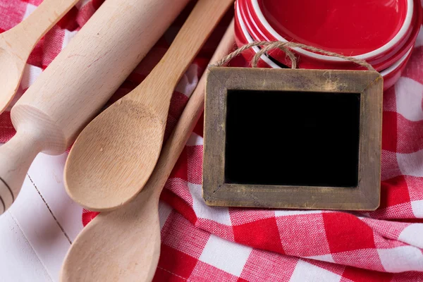 Kitchen towel, spoons, empty blackboard — Stock Photo, Image
