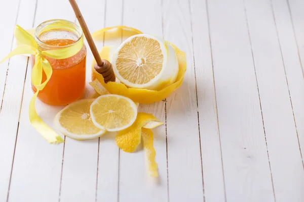 Lemons and honey in glass jar — Stock Photo, Image
