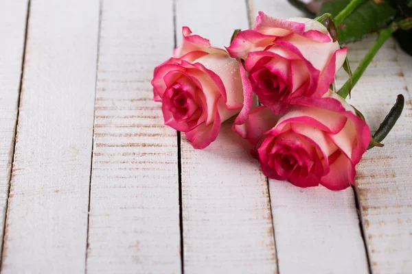 Rosas na mesa de madeira branca — Fotografia de Stock