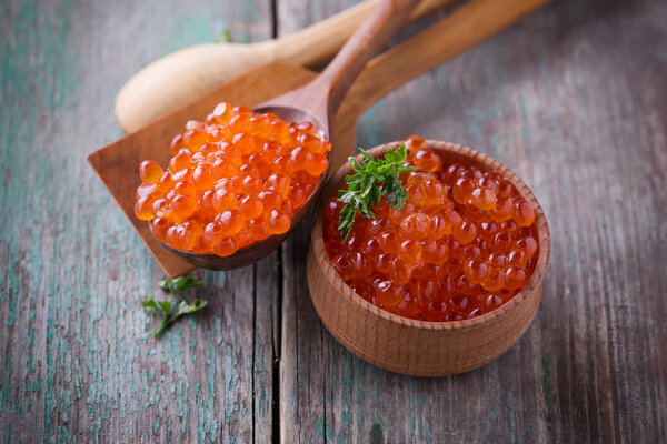 Red caviar on aged wooden background