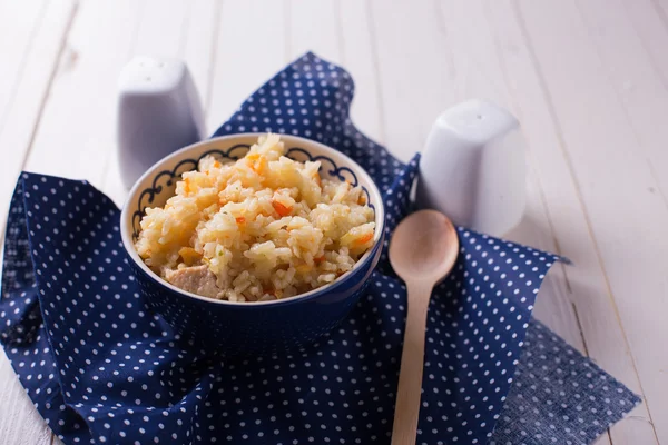 Pilaf in bowl on wooden table — Stock Photo, Image