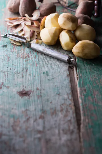 Batatas descascadas na mesa de madeira envelhecida — Fotografia de Stock