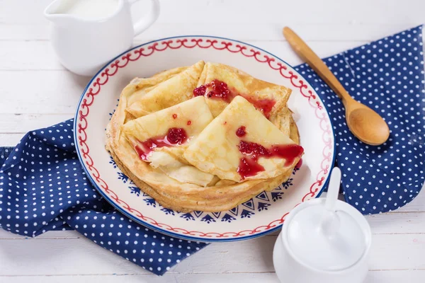 Pancakes or crepes on plate with raspberry jam — Stock Photo, Image