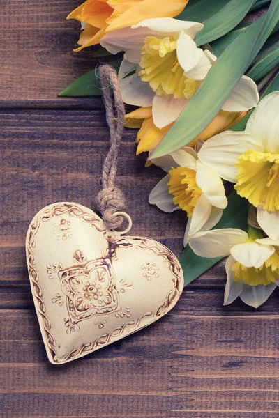 Pozadí s čerstvým narcisy a tulipány a dekorativní srdce — Stock fotografie