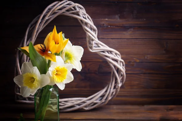 Tulipanes frescos, narcisos y corazón decorativo — Foto de Stock