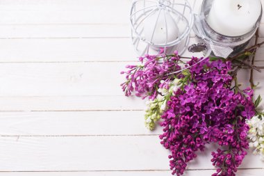 Eflatun çiçekler ve mumlar ahşap arka plan üzerinde.