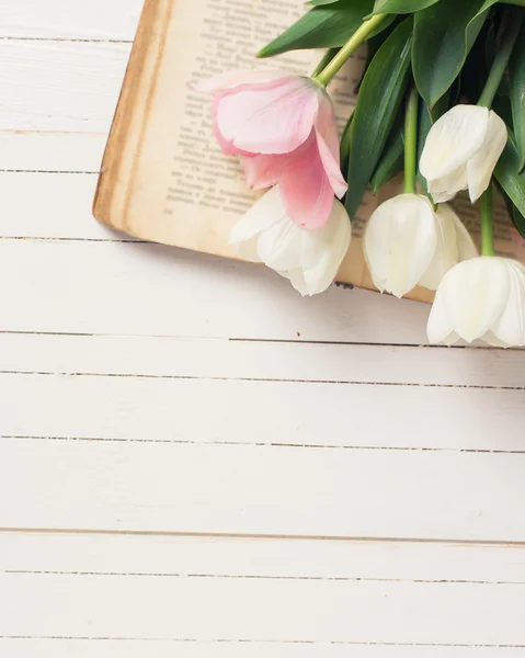 Bakgrund med tulpan blommor på vintage bok — Stockfoto