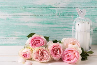 Gül ve kuş kafesi içinde mum