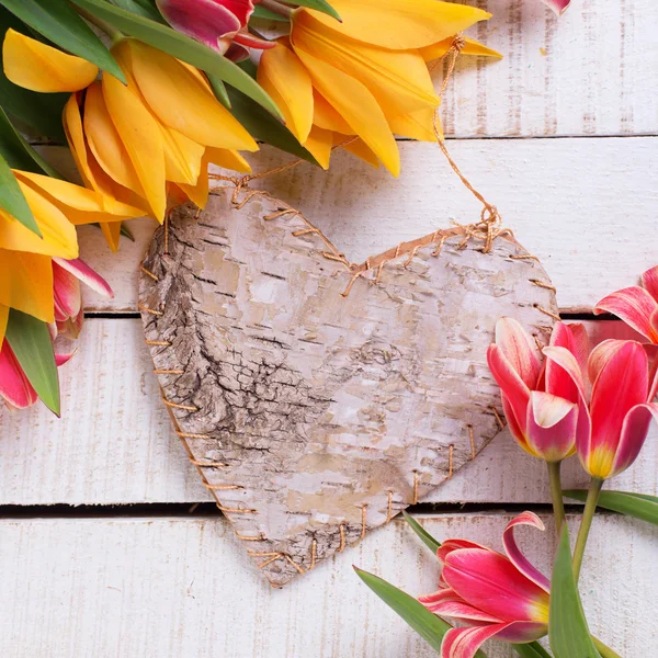 Yellow tulips  and rustic decorative heart — Φωτογραφία Αρχείου