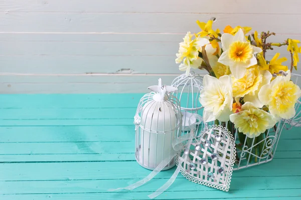 Narcisos amarillos flores y jaula decorativa — Foto de Stock