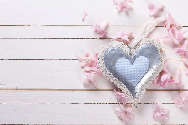 Corazón decorativo y pequeñas flores rosadas —  Fotos de Stock