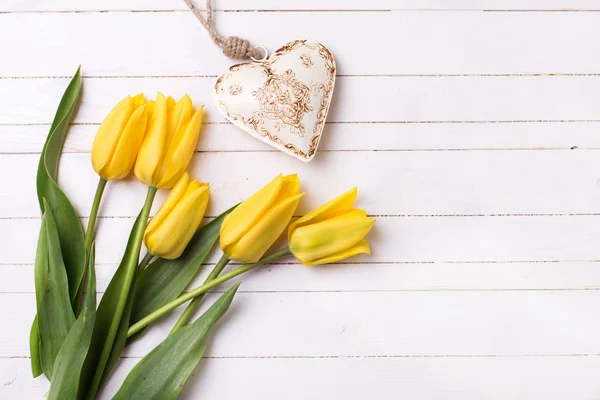 Flores frescas de tulipanes amarillos y corazón decorativo —  Fotos de Stock