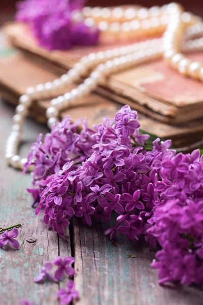 Fresh lilac flowers, old books and pear — Stockfoto