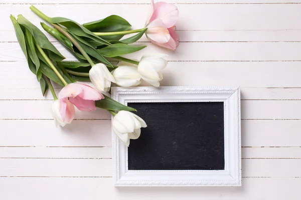 Белые тюльпаны и пустая доска — стоковое фото