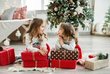 Noel ağacının yanında sevimli küçük kız kardeşler. Noel konsepti.