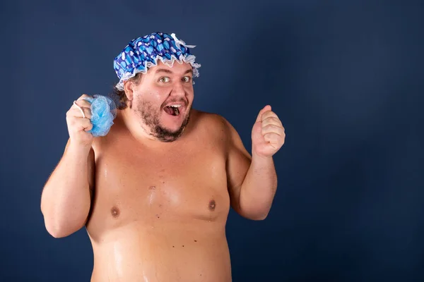 Engraçado homem gordo de boné azul cantar no chuveiro — Fotografia de Stock