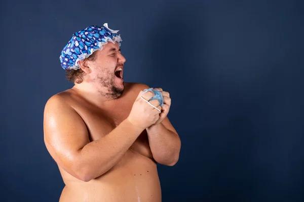 Divertido hombre gordo en gorra azul cantar en la ducha — Foto de Stock