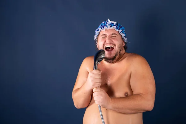 Divertido hombre gordo en gorra azul cantar en la ducha — Foto de Stock