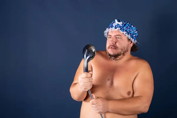 Engraçado homem gordo de boné azul cantar no chuveiro — Fotografia de Stock