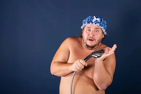 Engraçado homem gordo de boné azul cantar no chuveiro — Fotografia de Stock