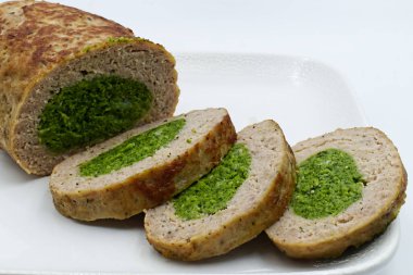 Beyaz arka planda ıspanaklı fırında köfte.