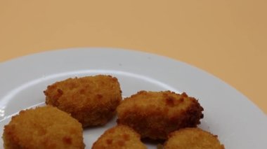 Beyaz tabakta kızarmış tavuk nuggetları.