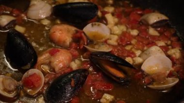 Kızartma tavasında deniz ürünleri sosu. Karides, midye, kabuk. Deniz ürünleri pişiriyorum..