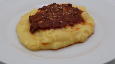 Bolonez soslu polenta ve beyaza izole edilmiş parmesan peyniri.