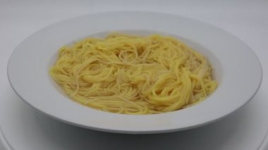 Geleneksel İtalyan taze Taglioline brodo, Taglioline et suyunda. Beyaz arkaplanda taze makarna