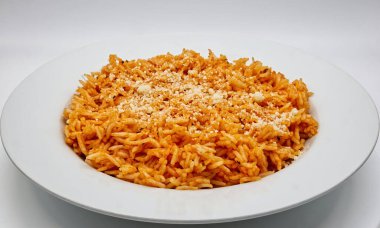 Domates soslu Basmati Rice ve beyaz tabakta parmesanlı reggiano peyniri..