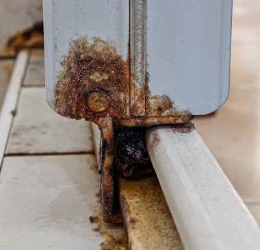 Duşun sürgülü kapısında pas var. Paslı yüzey. Pas kavramını kaldır