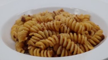 Beyaz arka planda izole edilmiş bolonez soslu ragu soslu Fusilli makarna. Yakın plan.