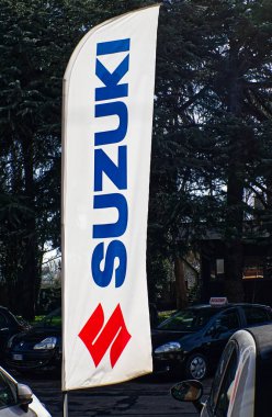 Bolonya 'da bir araba galerisinde logosu olan Suzuki Motor Şirketi bayrağı. İtalya