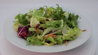 Taze karışık yeşil salata kasede dönüyor.