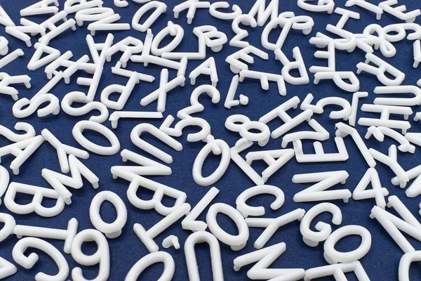 White letter and number are scattered chaotically on a table