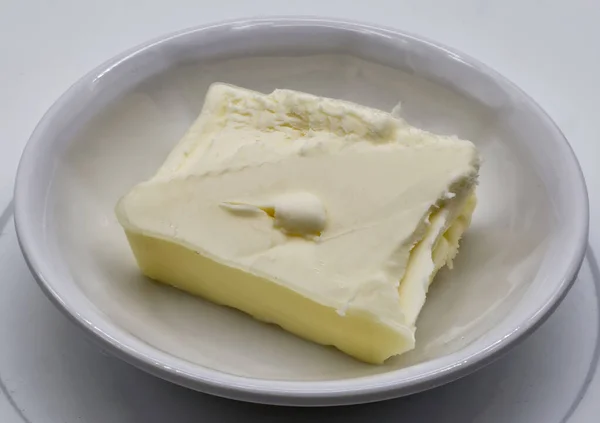 白い背景に隔離されたボウルにバター片 — ストック写真