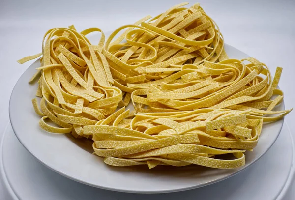 Tagliatelle Mentah Segar Italia Dalam Hidangan Putih Yang Diisolasi Pada — Stok Foto