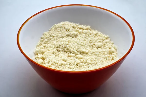 Izgara İtalyan Parmigiano Reggiano peyniri beyaz arka planda izole edilmiş kırmızı bir kasede.