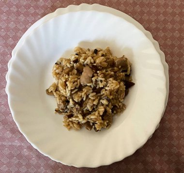 Beyaz tabakta İtalyan mantarlı risotto.
