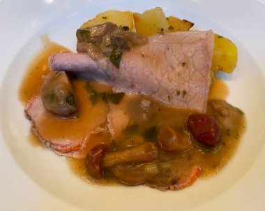 Bir tabak dana eti, mantar ve patates. İtalyan mutfağı.