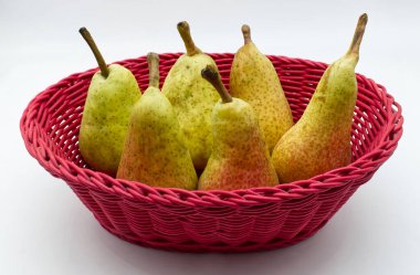 Beyaz arka planda izole edilmiş kırmızı sepetteki taze armutlar.