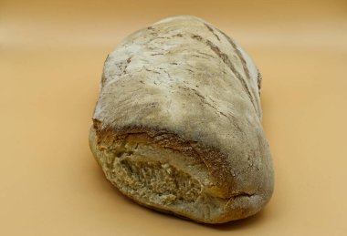 Yeni pişmiş bir ekmek somunu, yukarıdan, stüdyonun arka planında sıcak bronzlaşmış bir şekilde fotoğraflanır..