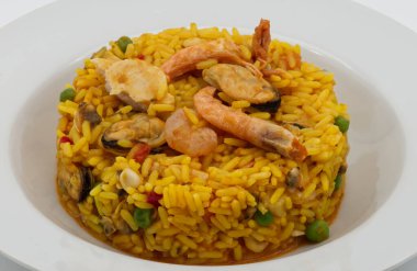 Lezzetli karides ve koyu midyelerle süslenmiş canlı ve iştah açıcı bir porsiyon, temiz beyaz bir tabakta güzelce sunuluyor..