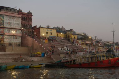Varanasi - Hindistan - 21 Şubat 2025: Ganj, Hindistan 'da turist botları ve antik tapınaklarla Varanasi nehir kenarının panoramik manzarası.