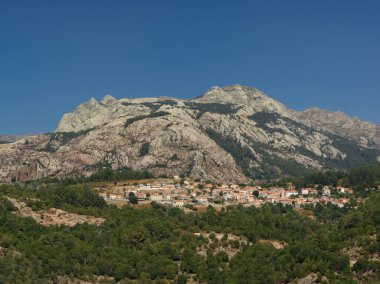 Korsika dağları içinde küçük köylü Evisa 'nın bulunduğu kayalardan ve ormandan oluşan bir manzara.
