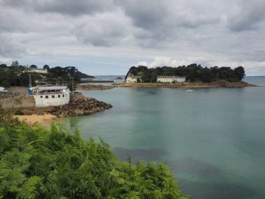 Brittany, Douarnenez 'de bulutlu gökyüzü ve berrak su olan bir körfez manzarası