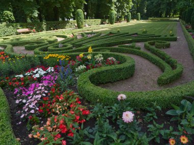 Echternach 'taki parkta çiçeklerle dolu güzel bahçedeki şekillerin manzarası. Yazın mavi gökyüzü.