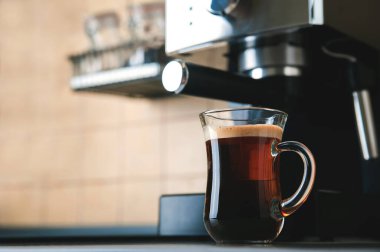 Şeffaf fincan kahve, yakın çekimde. Ev yapımı kahve makinesi ve kahve yapma süreci. Kahve çekirdekleri ve kopyalama alanından ayrıl.